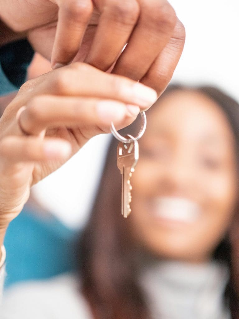 A lady holding keys to her house